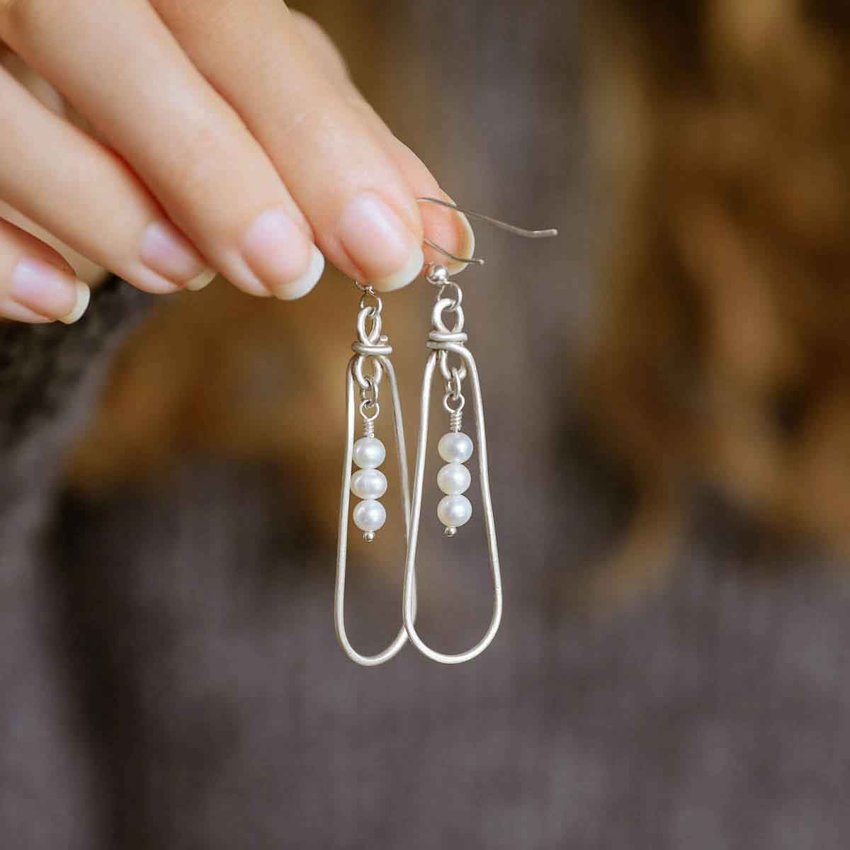 girl holding a mother's love sterling silver pearl earrings