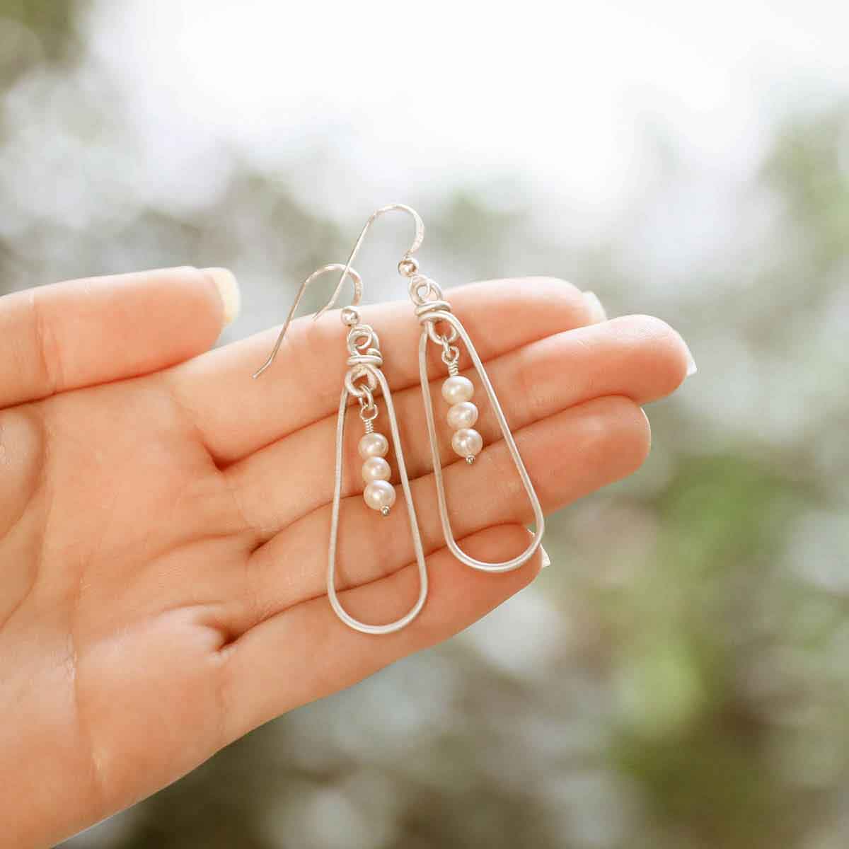 girl holding a mother's love sterling silver pearl earrings