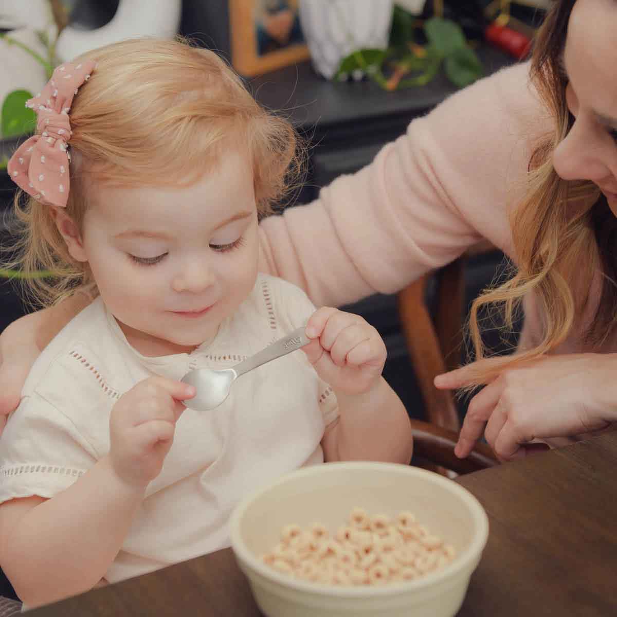 baby girl holding an Adorable Baby’s First Spoon