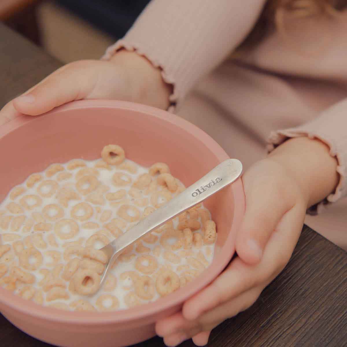 baby girl holding an Adorable Baby’s First Spoon