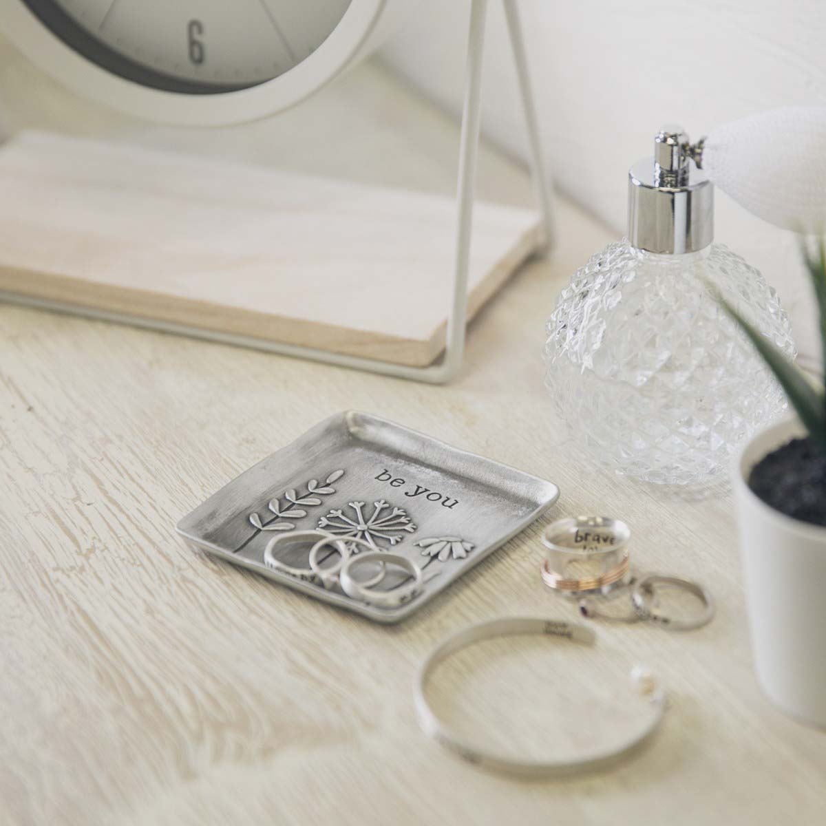 hand putting a ring on the be you pewter keepsake dish