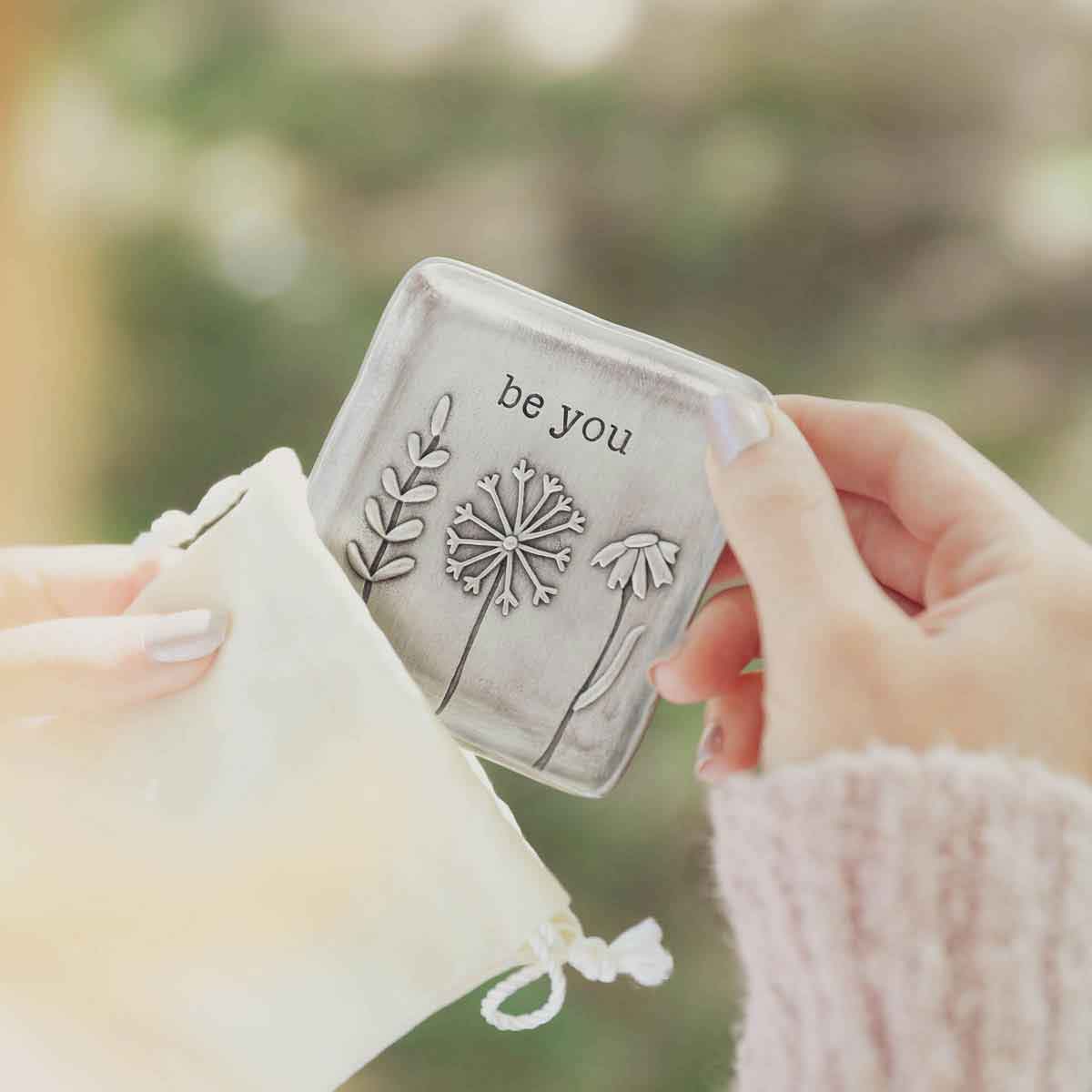 hands holding the be you pewter keepsake dish