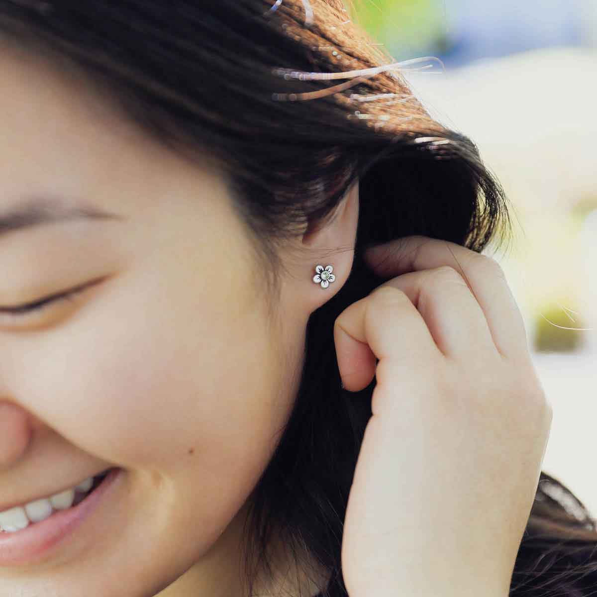 close up of girl wearing sterling silver birthstone bloom stud earrings with personalized birthstone