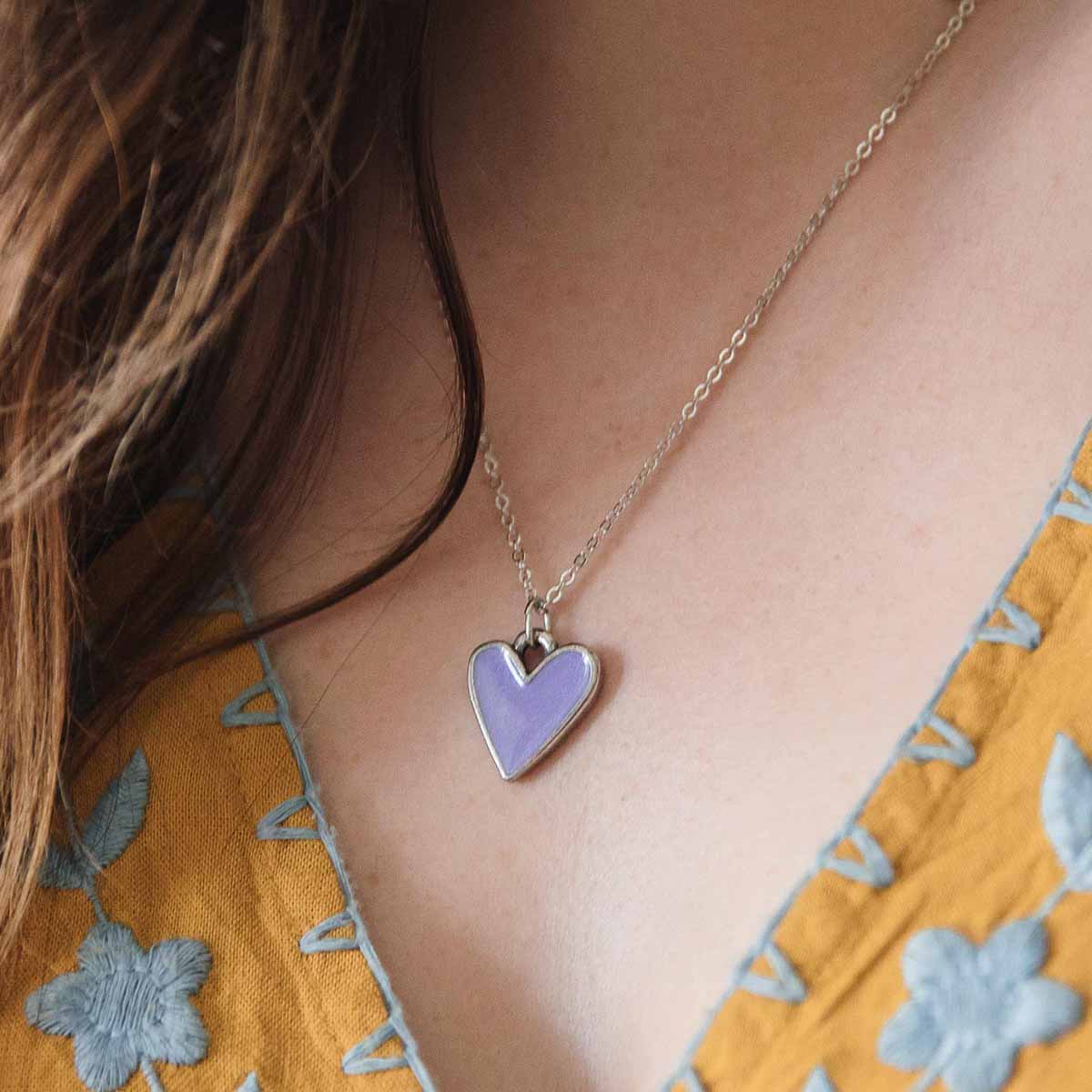 Girl wearing her Brave Love heart necklace handcrafted in pewter with choice of color epoxy