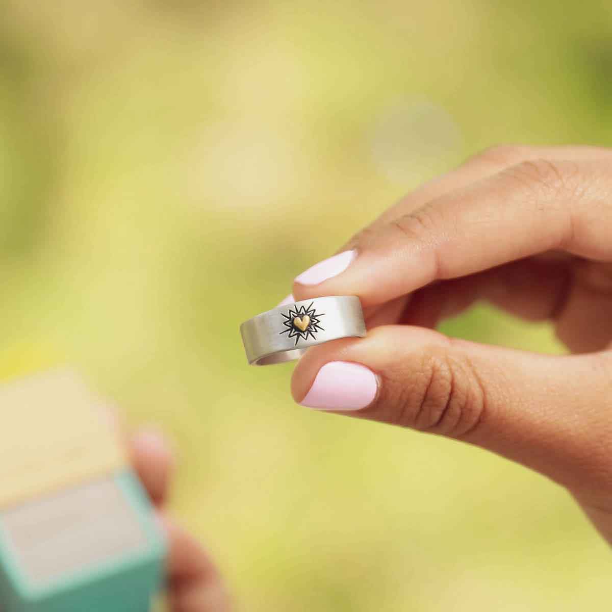 girl holding sterling silver bursting heart ring
