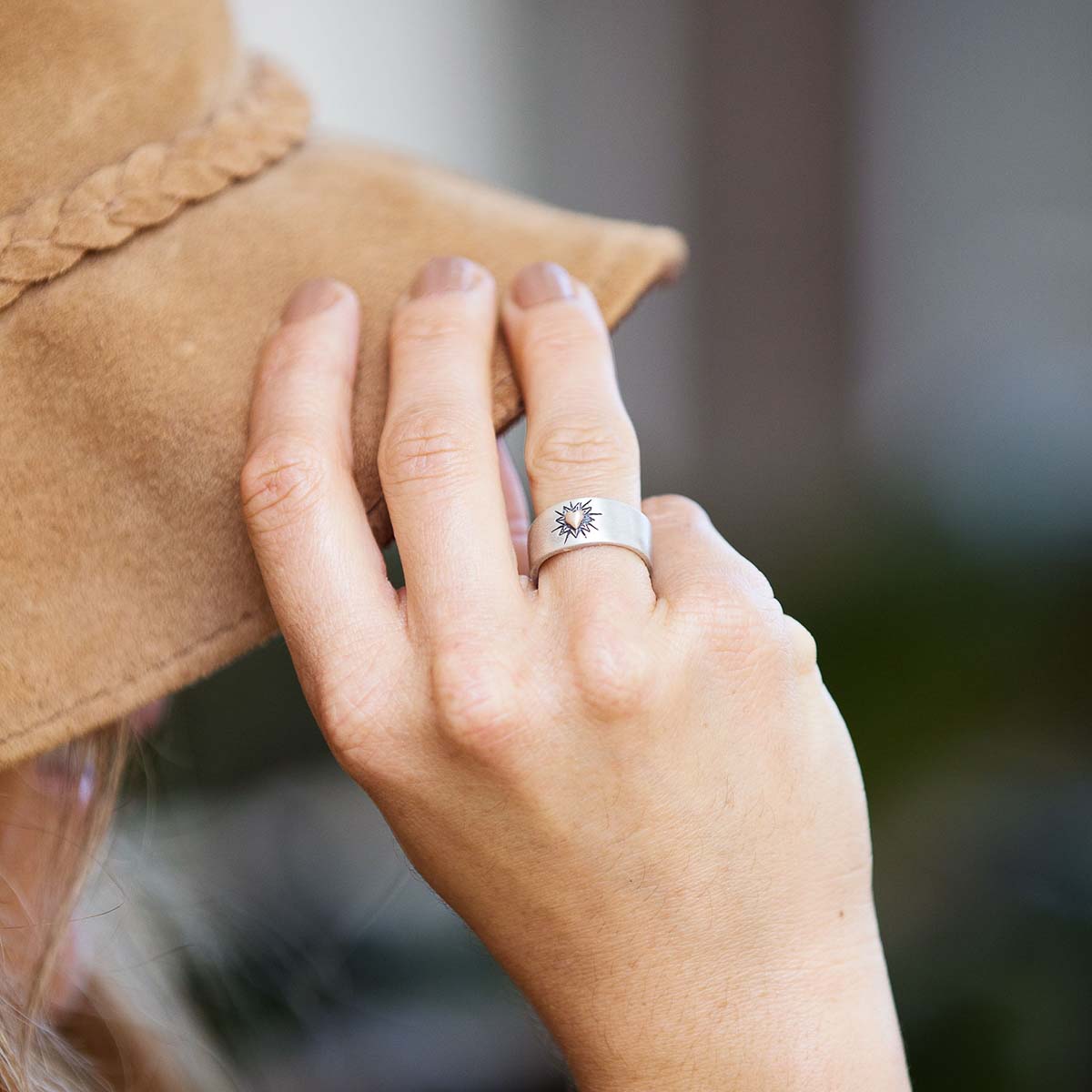 Girl wearing Bursting heart ring hand-molded sterling silver finished with a 10k yellow gold heart and hand-engraved with sunburst design
