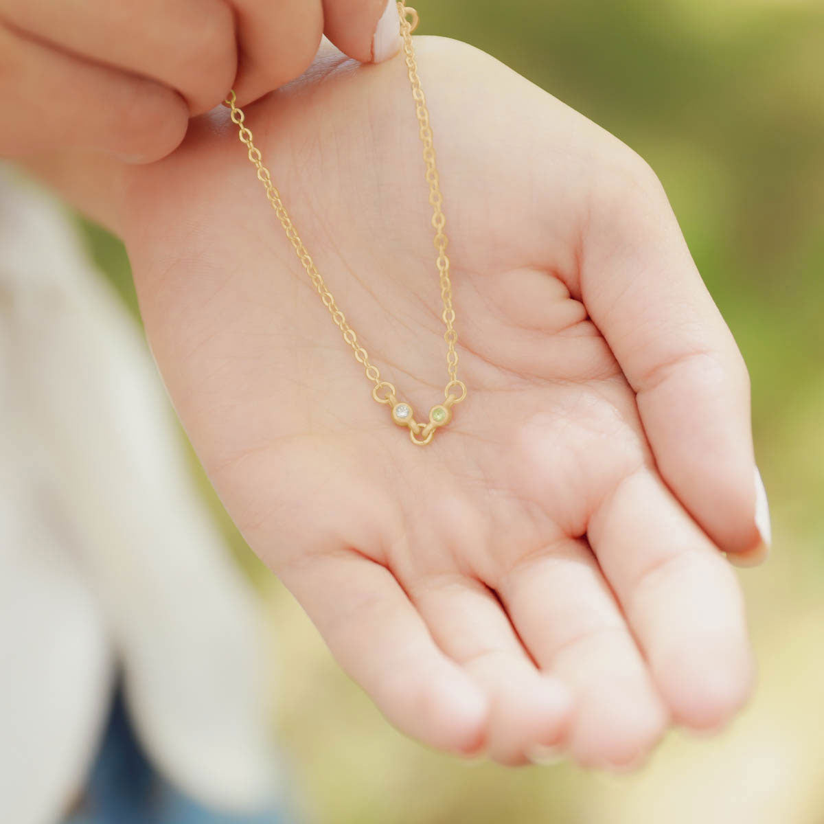 girl holding 14k yellow gold Dainty Finespun Birthstone Bracelet - Small