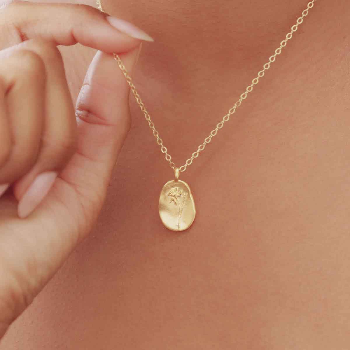 girl wearing a gold plated December birth flower necklace with an 18" gold filled link chain