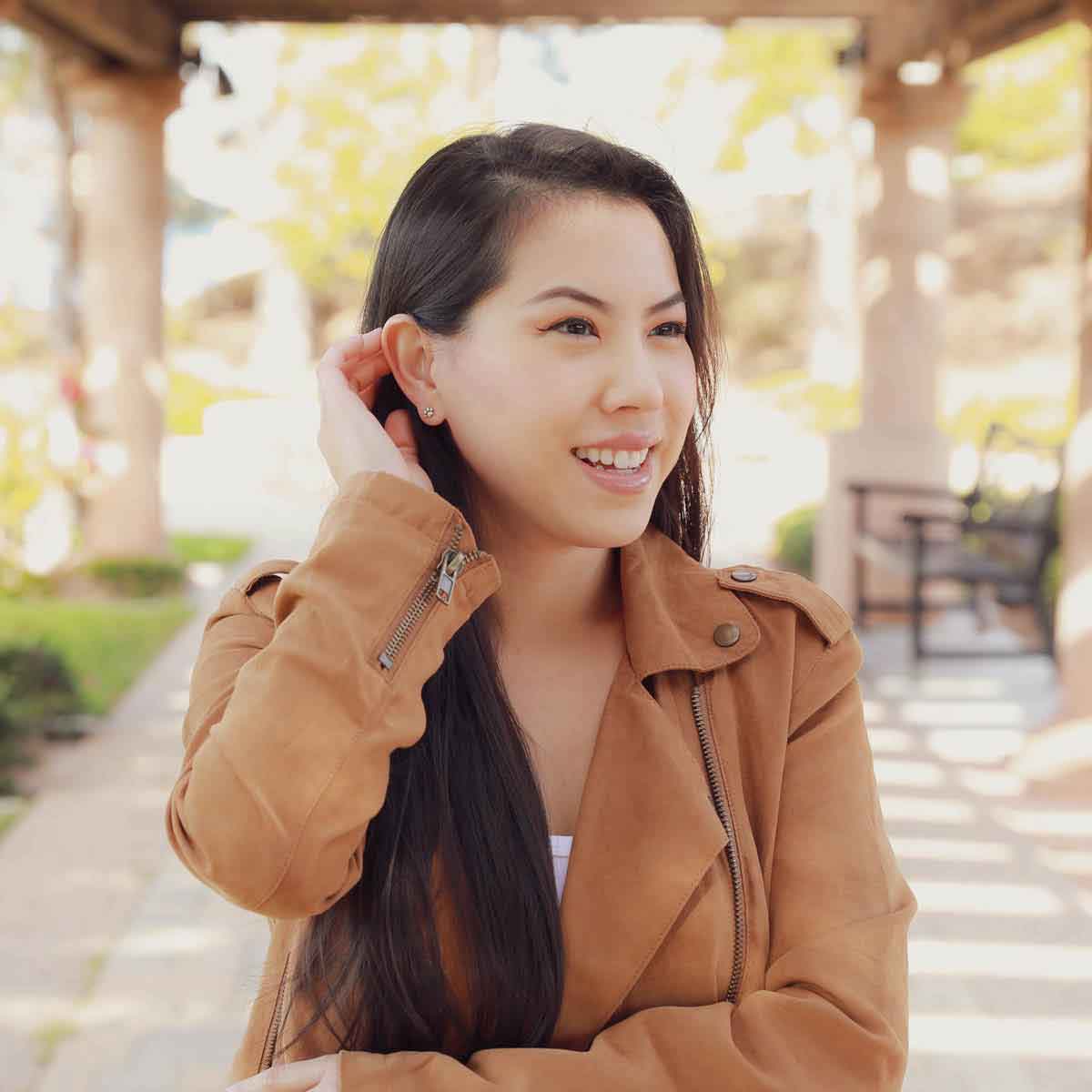 girl holding Furry Footprint Stud Earrings handcrafted in sterling silver in a lisa leonard box