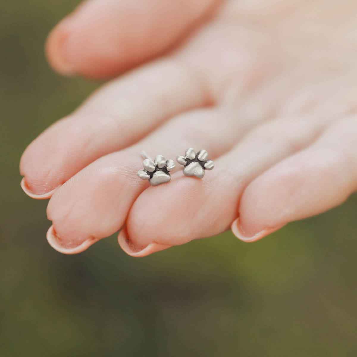 girl wearing Furry Footprint Stud Earrings handcrafted in sterling silver