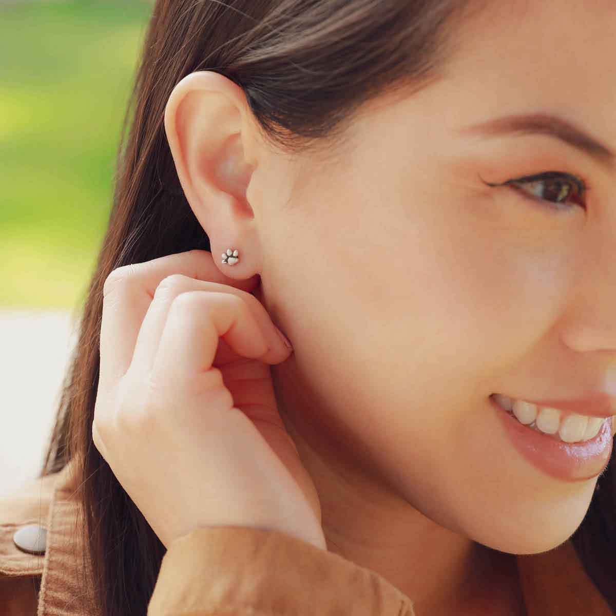 girl wearing Furry Footprint Stud Earrings handcrafted in sterling silver