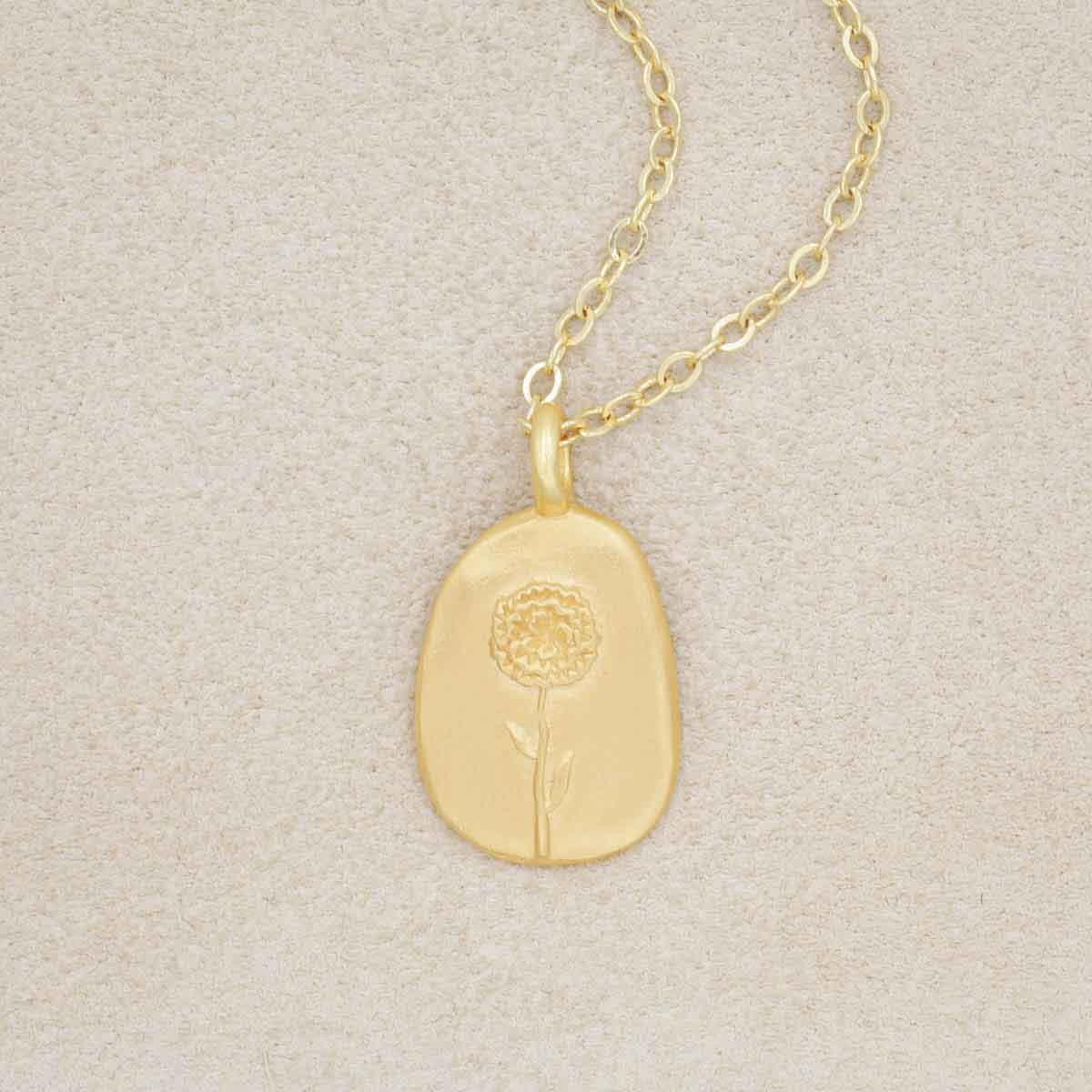 gold plated January birth flower necklace with an 18" gold filled link chain, on a beige background