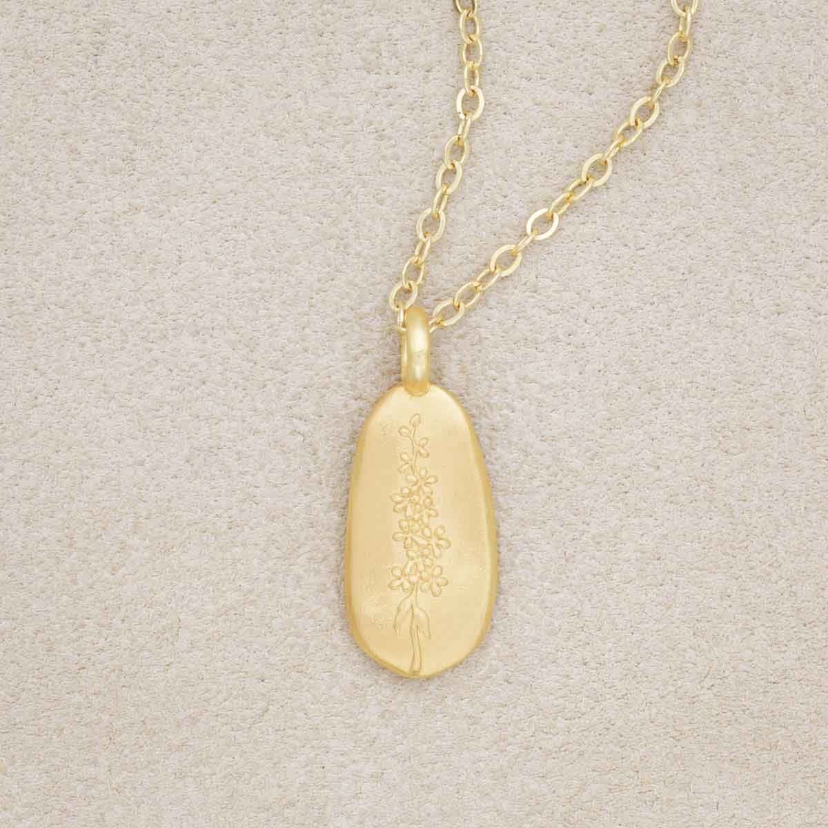 gold plated July birth flower necklace with an 18" gold filled link chain, on beige background