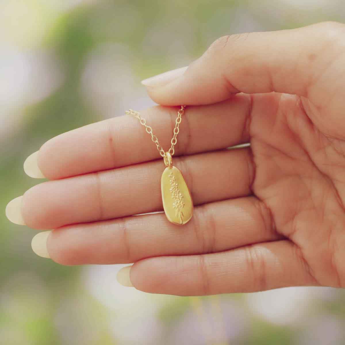 girl wearing a gold plated July birth flower necklace with an 18" gold filled link chain