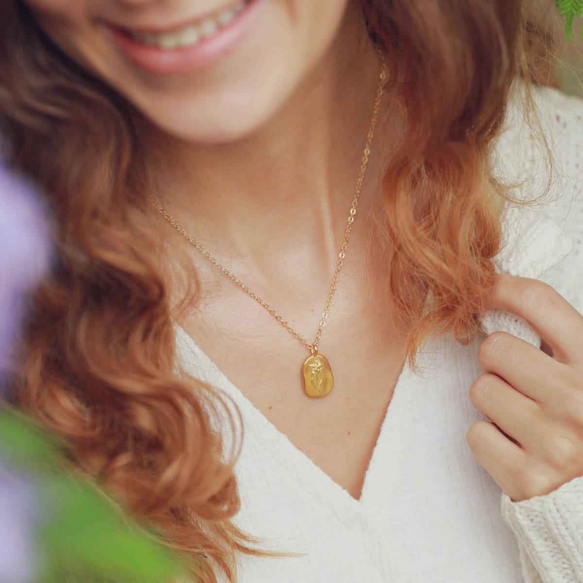 girl wearing a gold plated March birth flower necklace with an 18" gold filled link chain