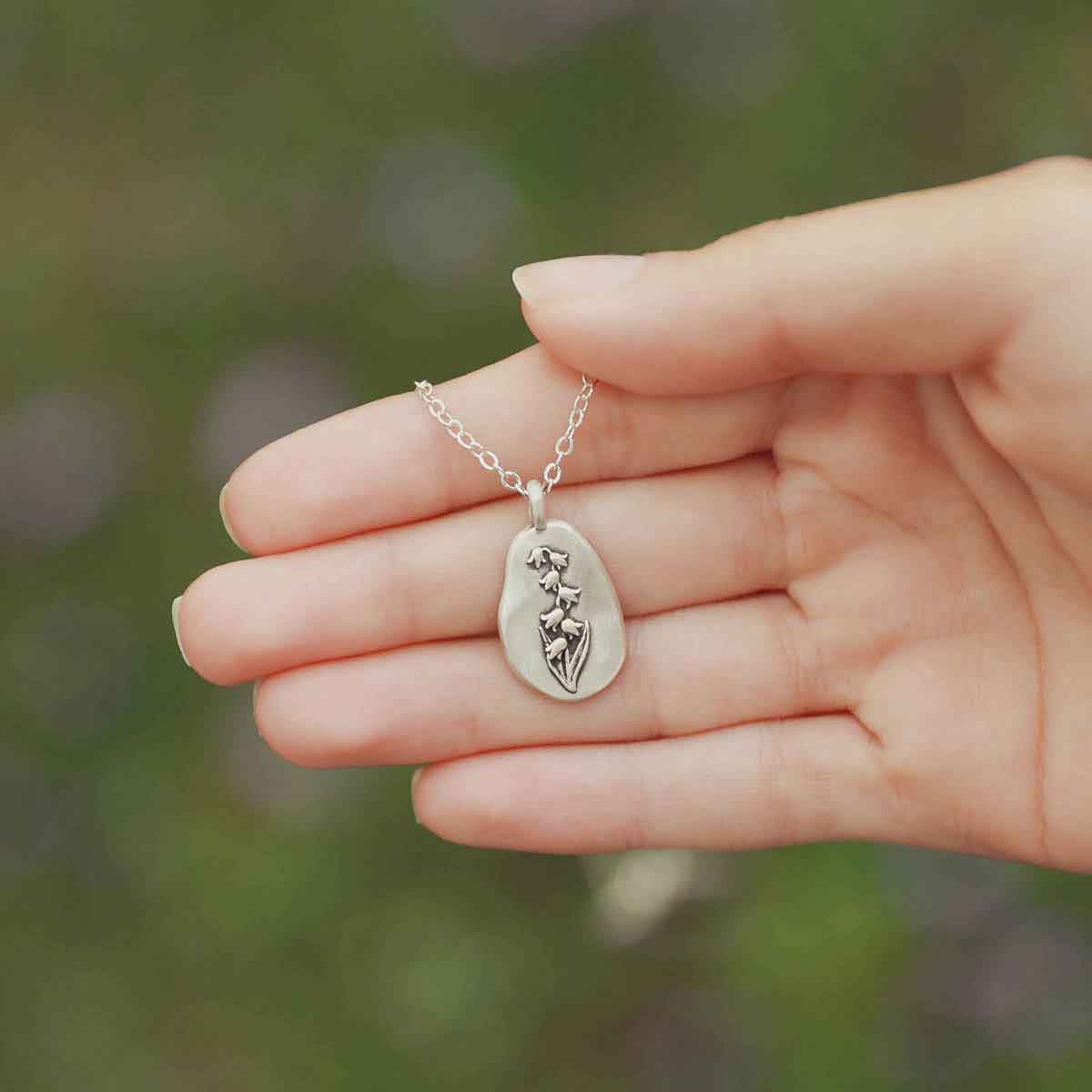 girl wearing a sterling silver May Birth flower necklace