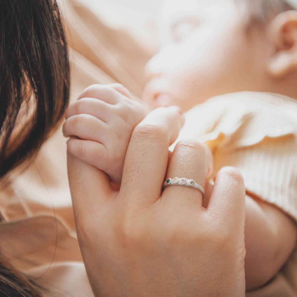 holding her baby's hand
