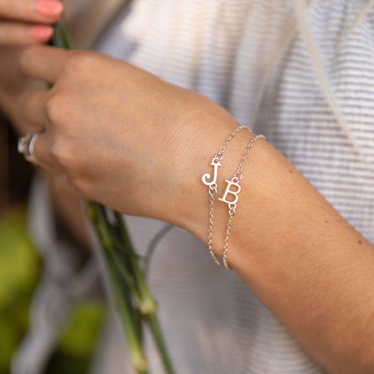 Girl wearing a pair of Sterling silver monogram bracelets with a satin finish