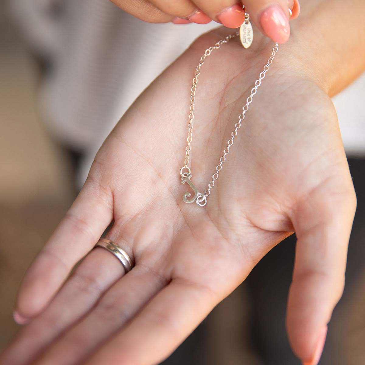 Girl showing her Sterling silver monogram bracelet with a satin finish