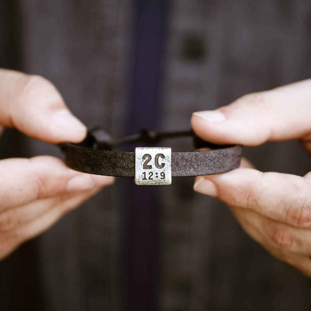 man holding a black Equitable Leather Verse Bracelet