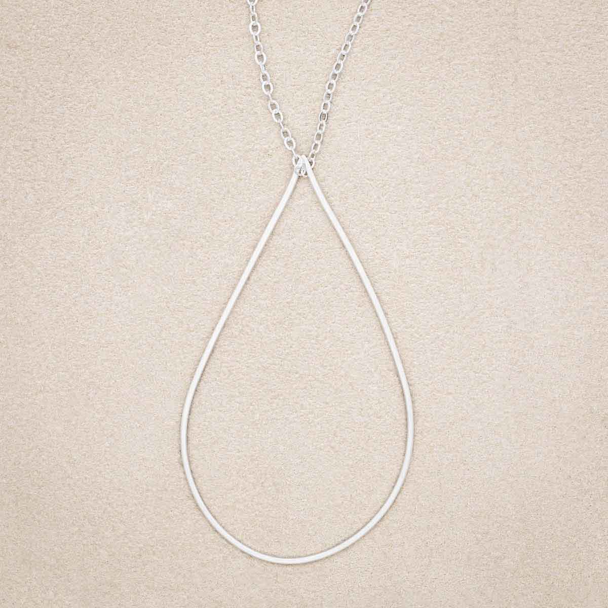 Sorrow and Joy Teardrop Necklace, handcrafted in sterling silver, on suede background