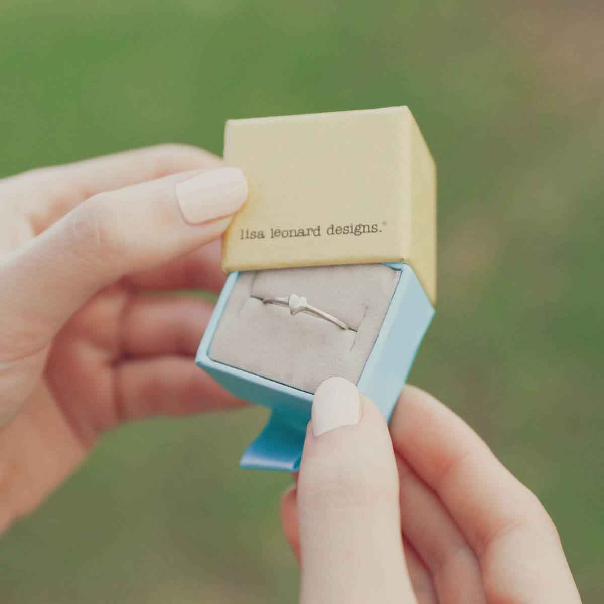 girl holding a sterling silver sweet love ring - one heart in a lisa leonard ring box