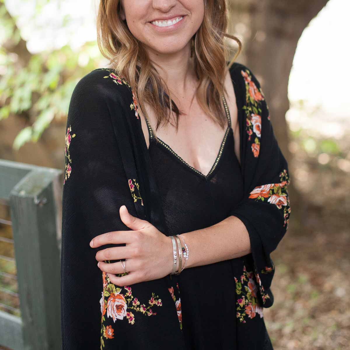 Girl wearing sterling silver and gold jewelry including a thin gold cuff