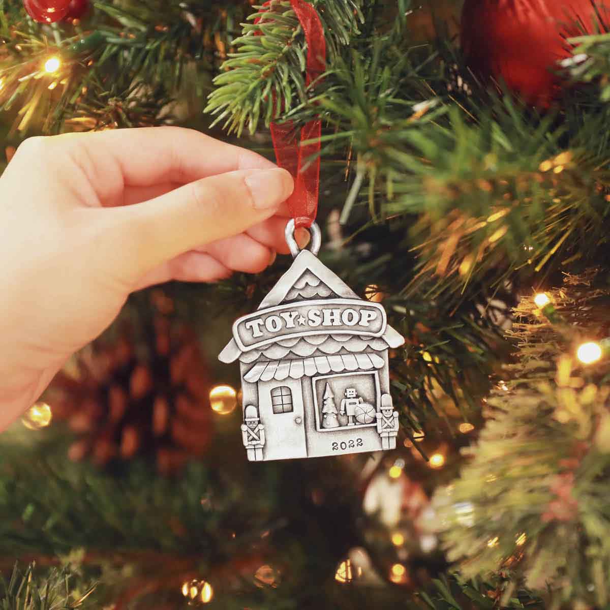 hand holding a Toy Shop Ornament cast in pewter