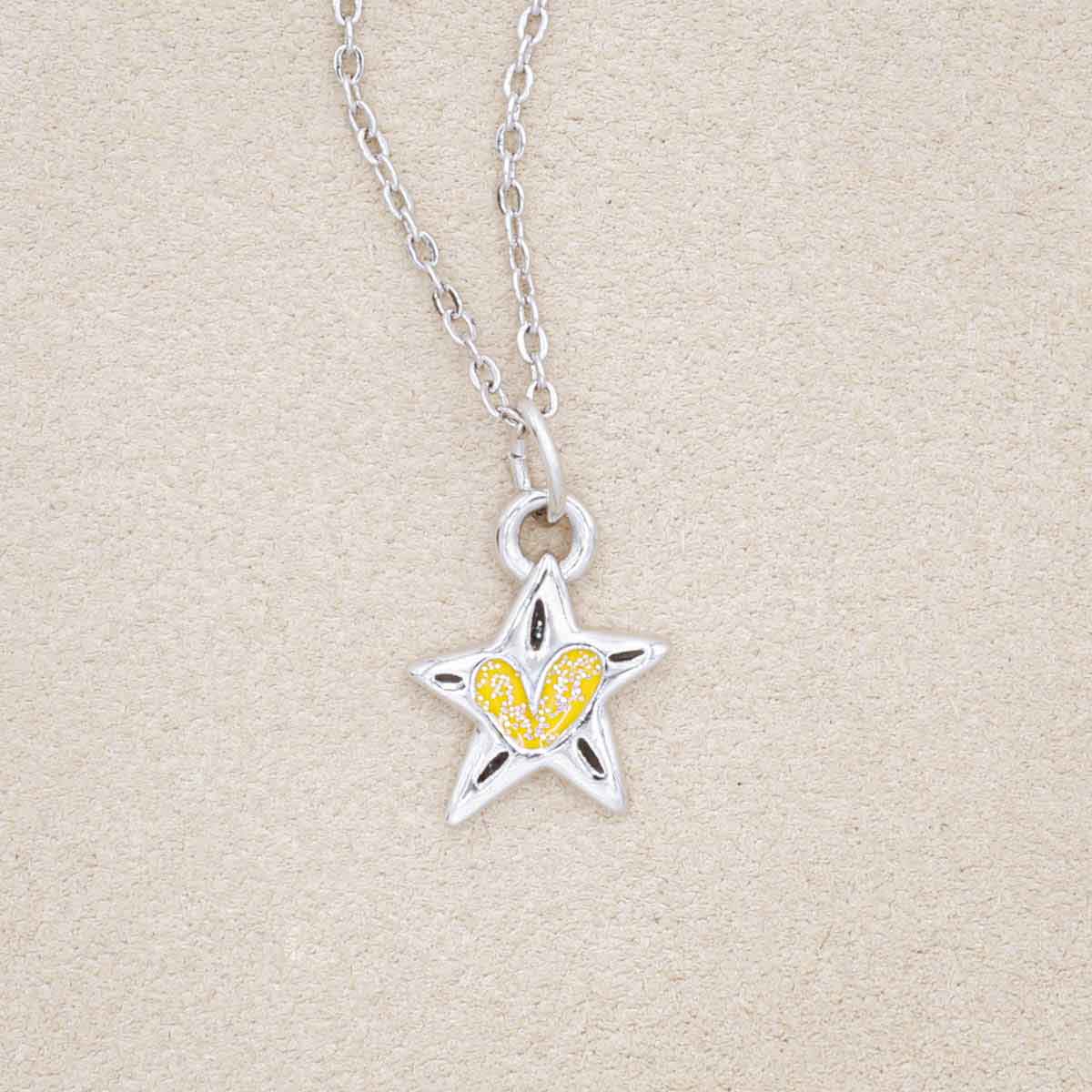 your spark kids necklace, filled with glitter yellow epoxy, on a beige background