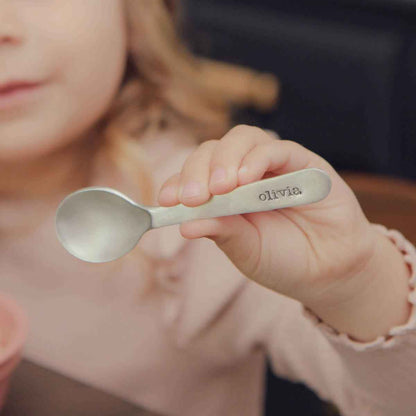 baby girl holding an Adorable Baby’s First Spoon