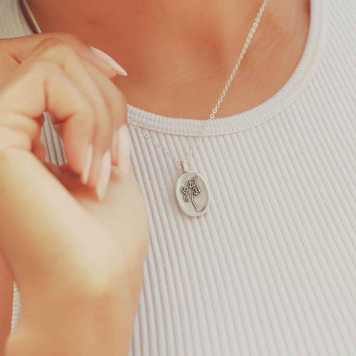 girl wearing a pewter April Birth Flower necklace with 18" link chain