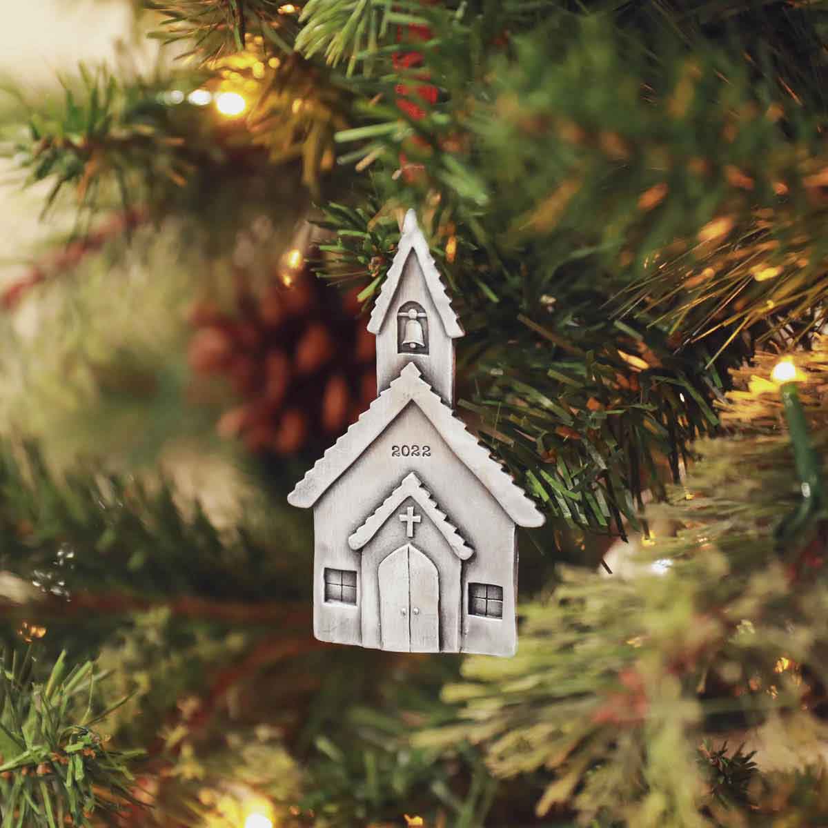 a Church Bells Ornament hanging on a Christmas tree