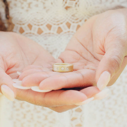 Girl wearing her Faith Hope and Love ring hand-molded in 14k yellow gold set with a 3mm birthstone or diamond and two 2mm stones on the sides