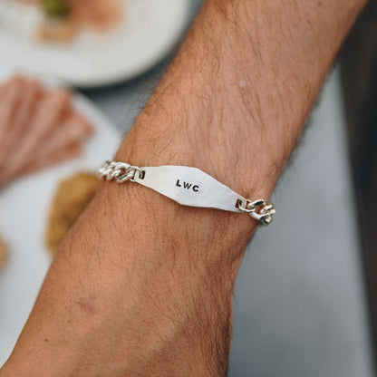 man wearing a sterling silver Identity Bracelet with a hand stamped personalized metal plate