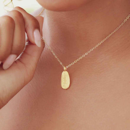 girl holding a gold plated July birth flower necklace with an 18" gold filled link chain