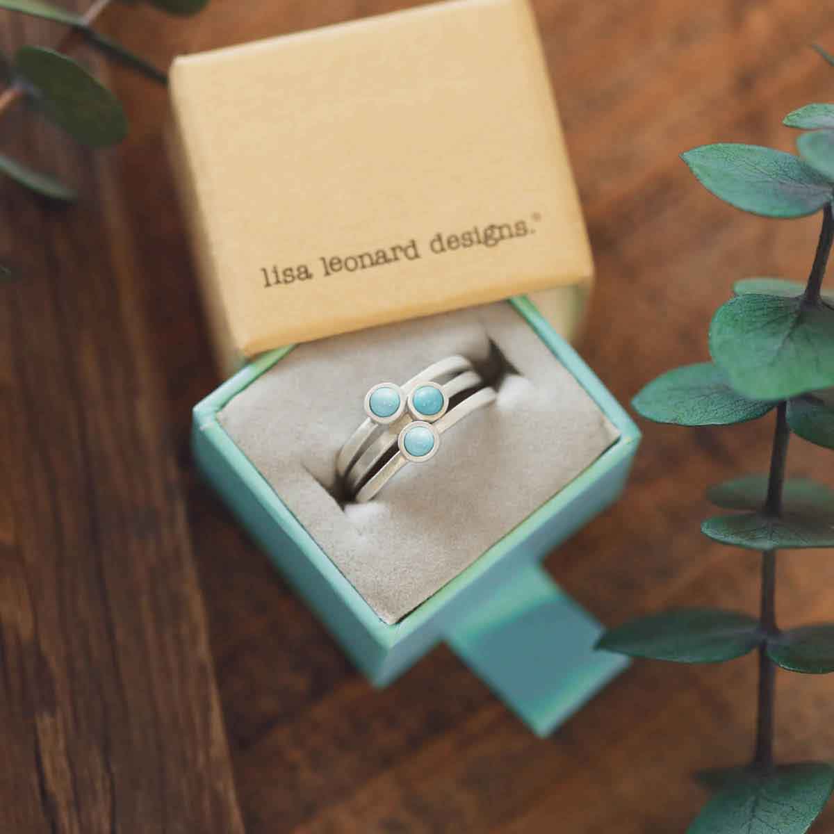 girl stacking two sterling silver Lighthearted Turquoise Rings on her finger