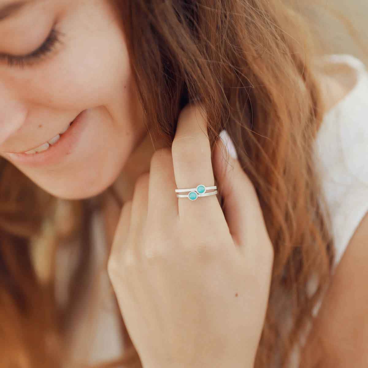 girl stacking two sterling silver Lighthearted Turquoise Rings on her finger