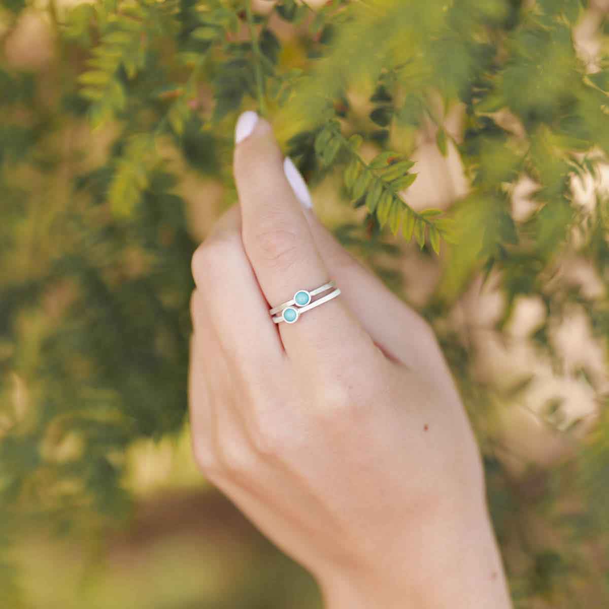 girl stacking two sterling silver Lighthearted Turquoise Rings on her finger