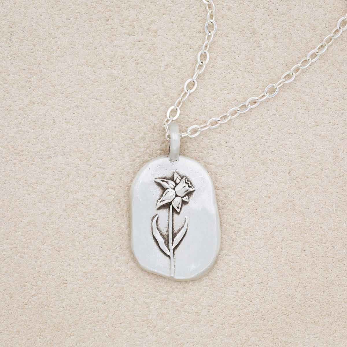 sterling silver March birth flower necklace, on beige background