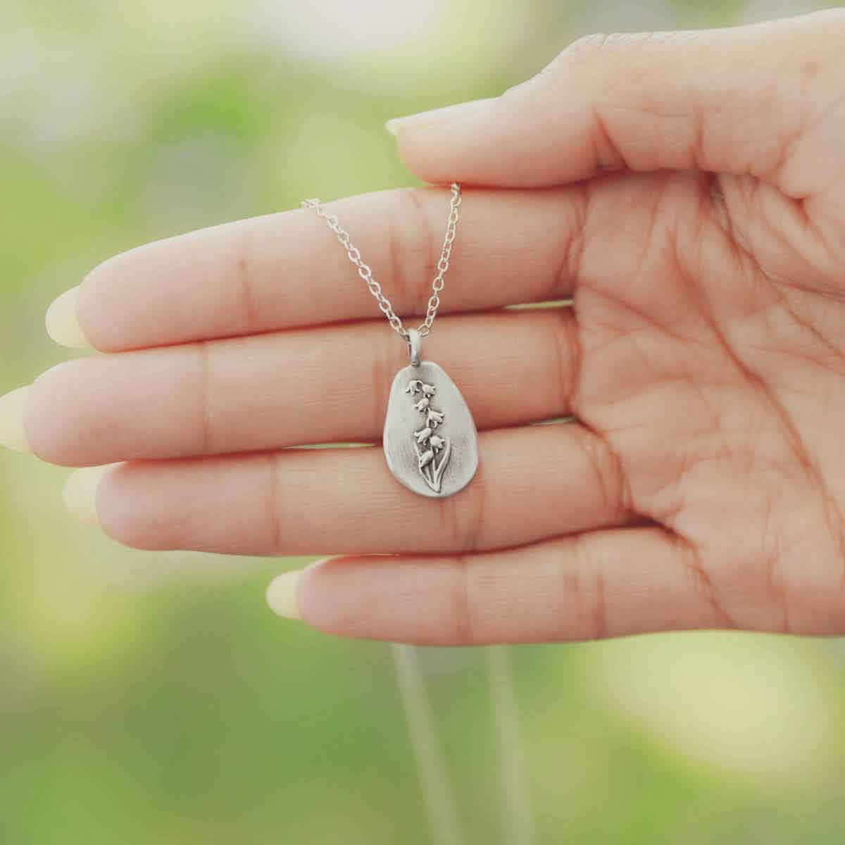 girl wearing a pewter May Birth Flower necklace with 18" link chain