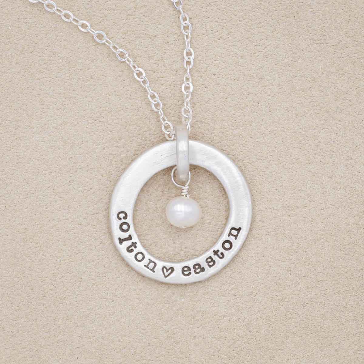 sterling silver open circle pearl necklace, on marble background