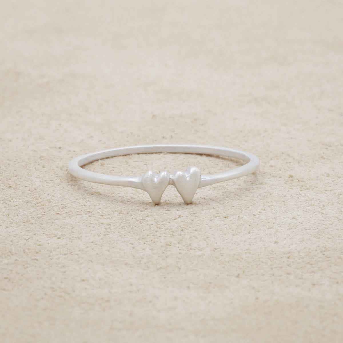 sterling silver sweet love ring with two hearts on a suede background
