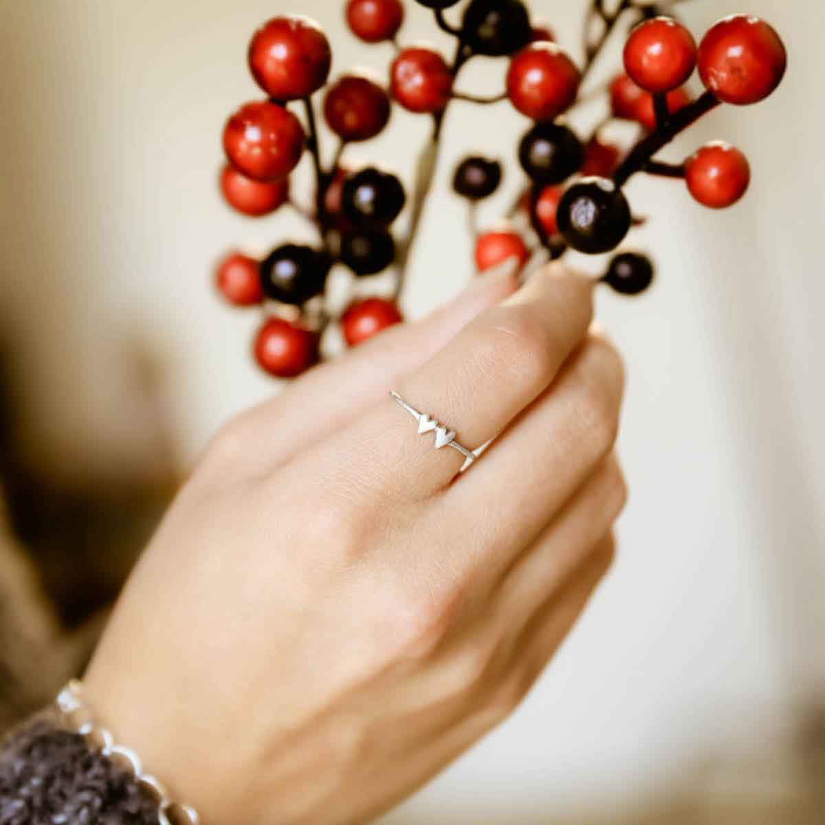girl holding sterling silver sweet love ring - two hearts