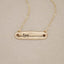 10k yellow gold written with love necklace, on beige background