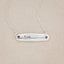 sterling silver written with love necklace, on a beige background