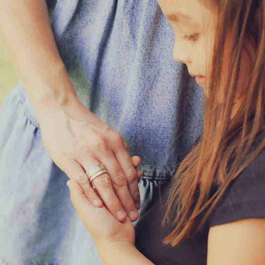 mom wearing the you have my heart spinner ring {sterling silver & 10k gold} holding daughter